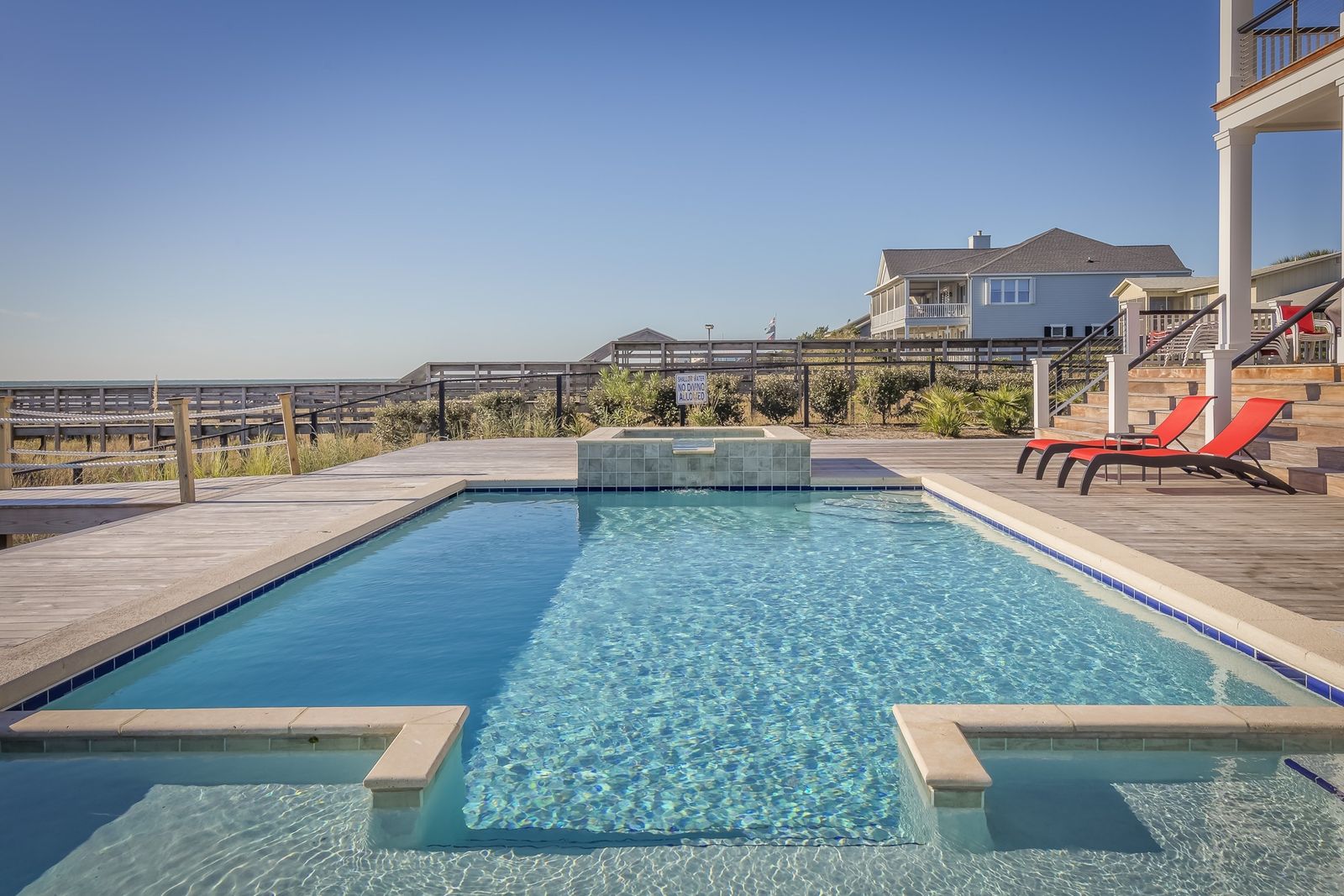 A crystal-clear backyard swimming pool under bright blue Southern Utah sky in St. George