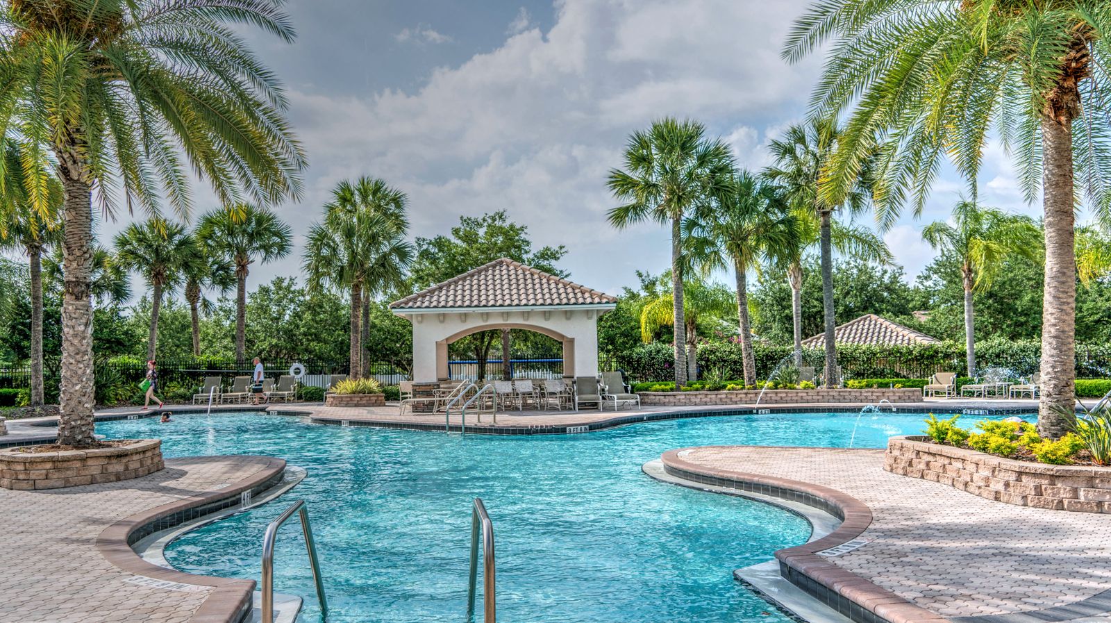 A large resort-style pool surrounded by palms, kept clean and clear